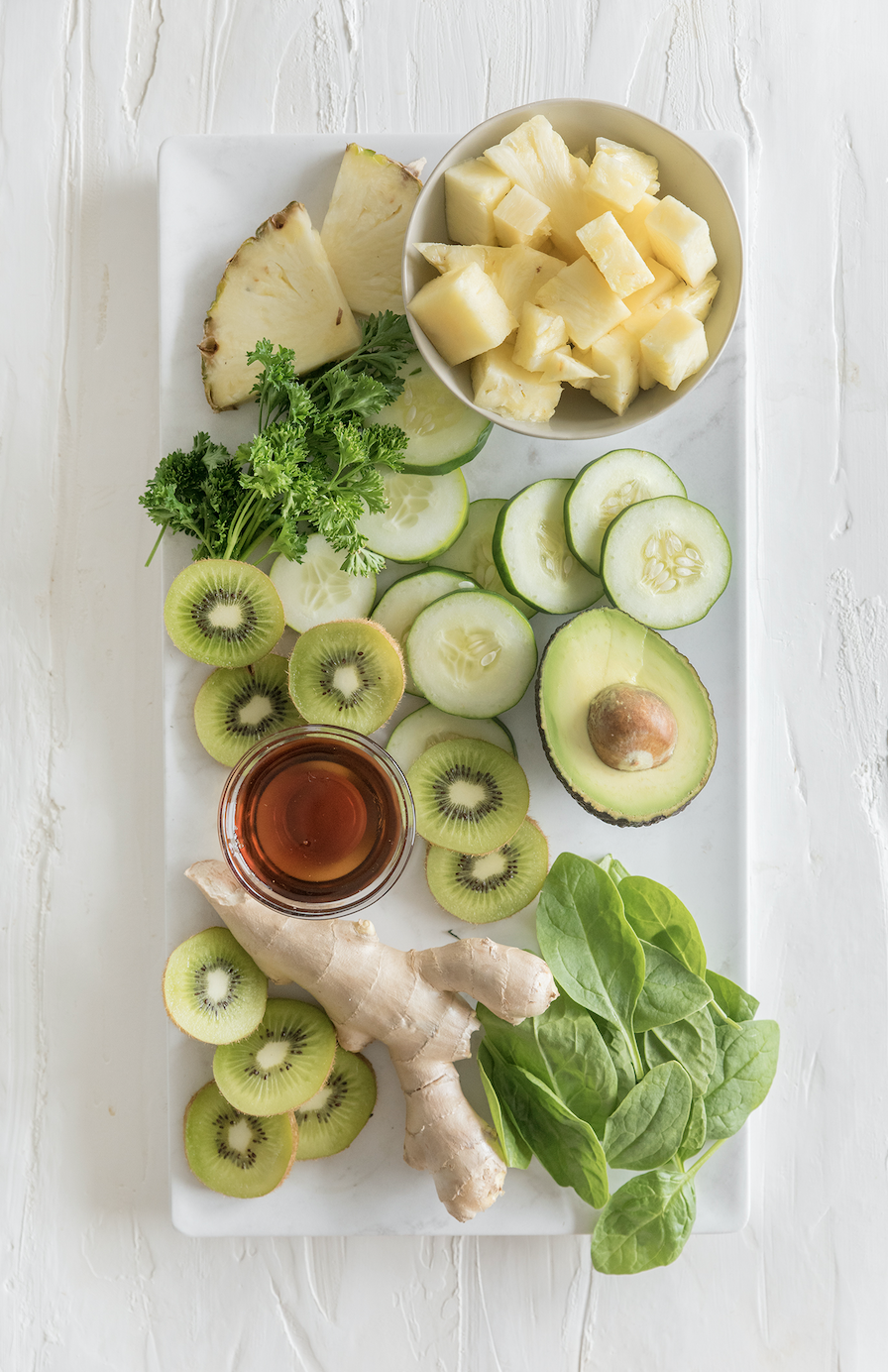 plate of kiwi, pineapple, avocados, greens, cucumbers, and ginger