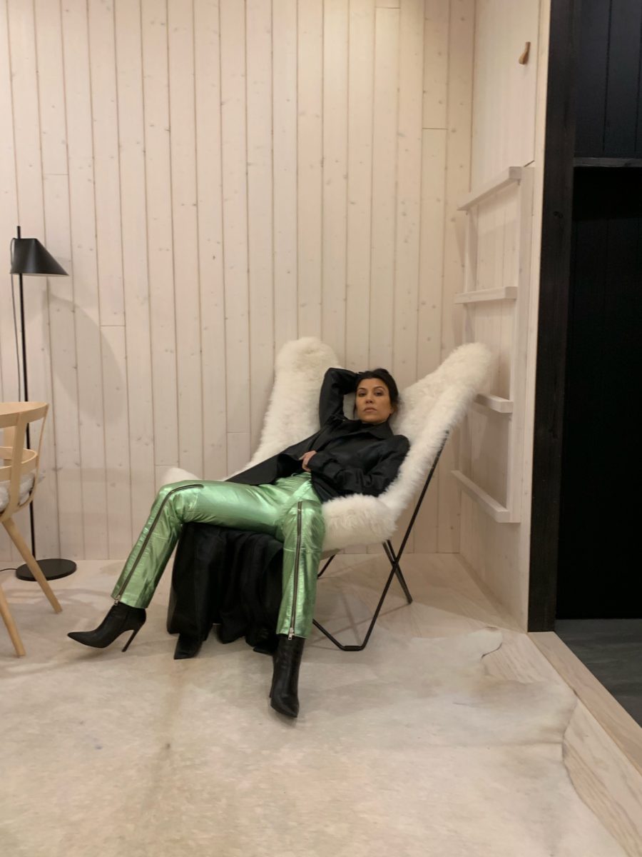kourtney kardashian posing in chair wearing green pants