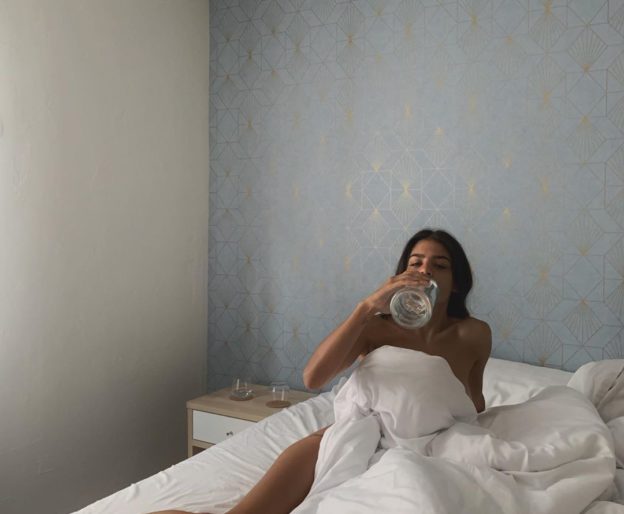 woman in bed drinking water