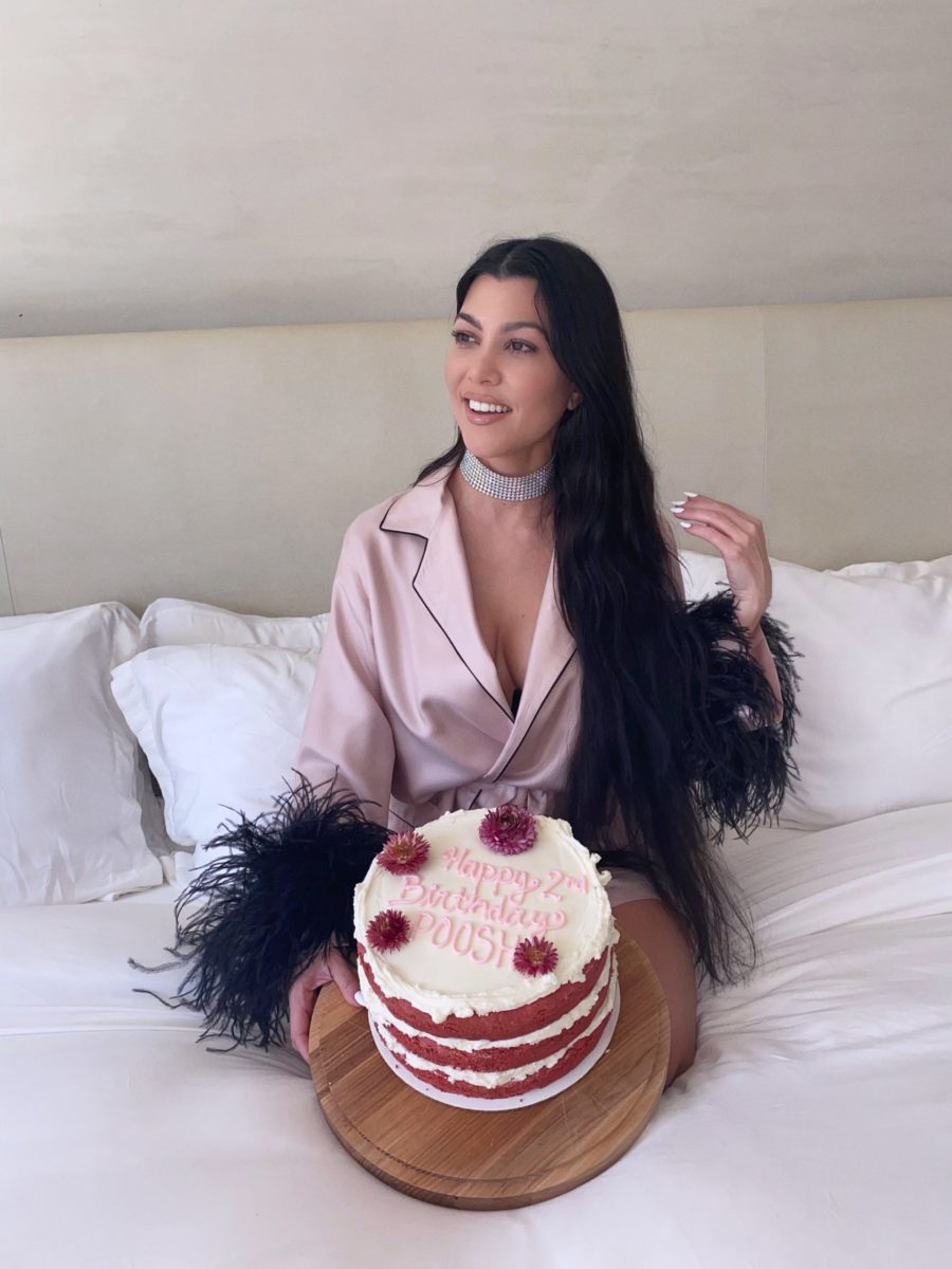 kourtney kardashian in silk pjs in bed with cake
