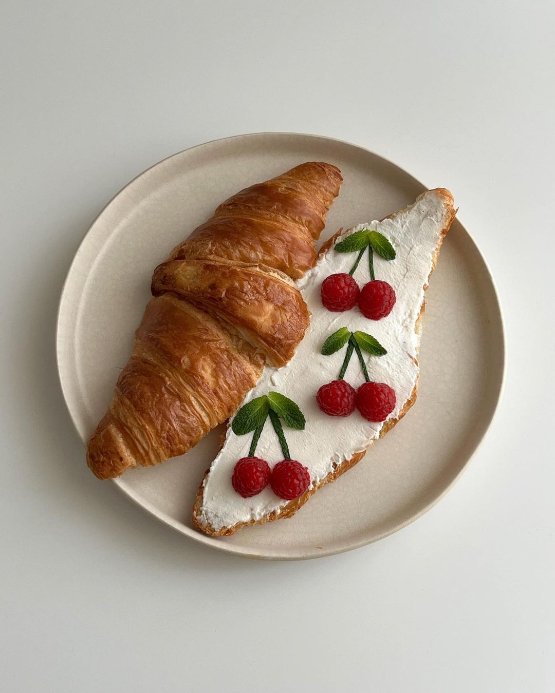 whipped cheese and berries in shape of cherries on croissant