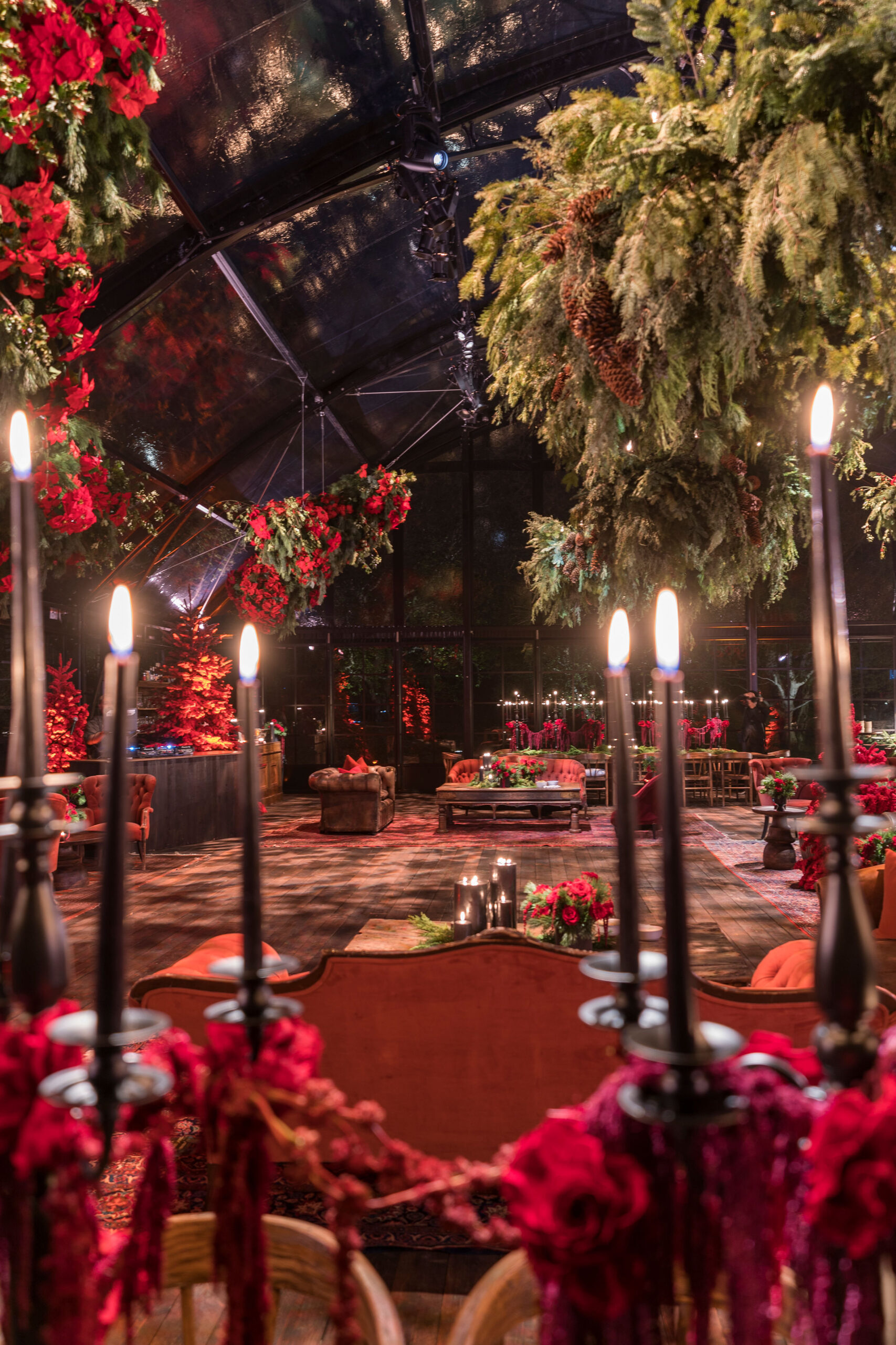 Lit tapered candles on a table spread at Kourtney Kardashian Barker&#8217;s 2022 Christmas Eve Party in a glass tent
