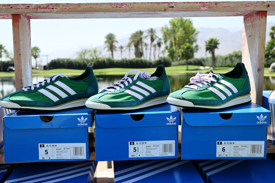 Three green Adidas shoes on top of shoe boxes.
